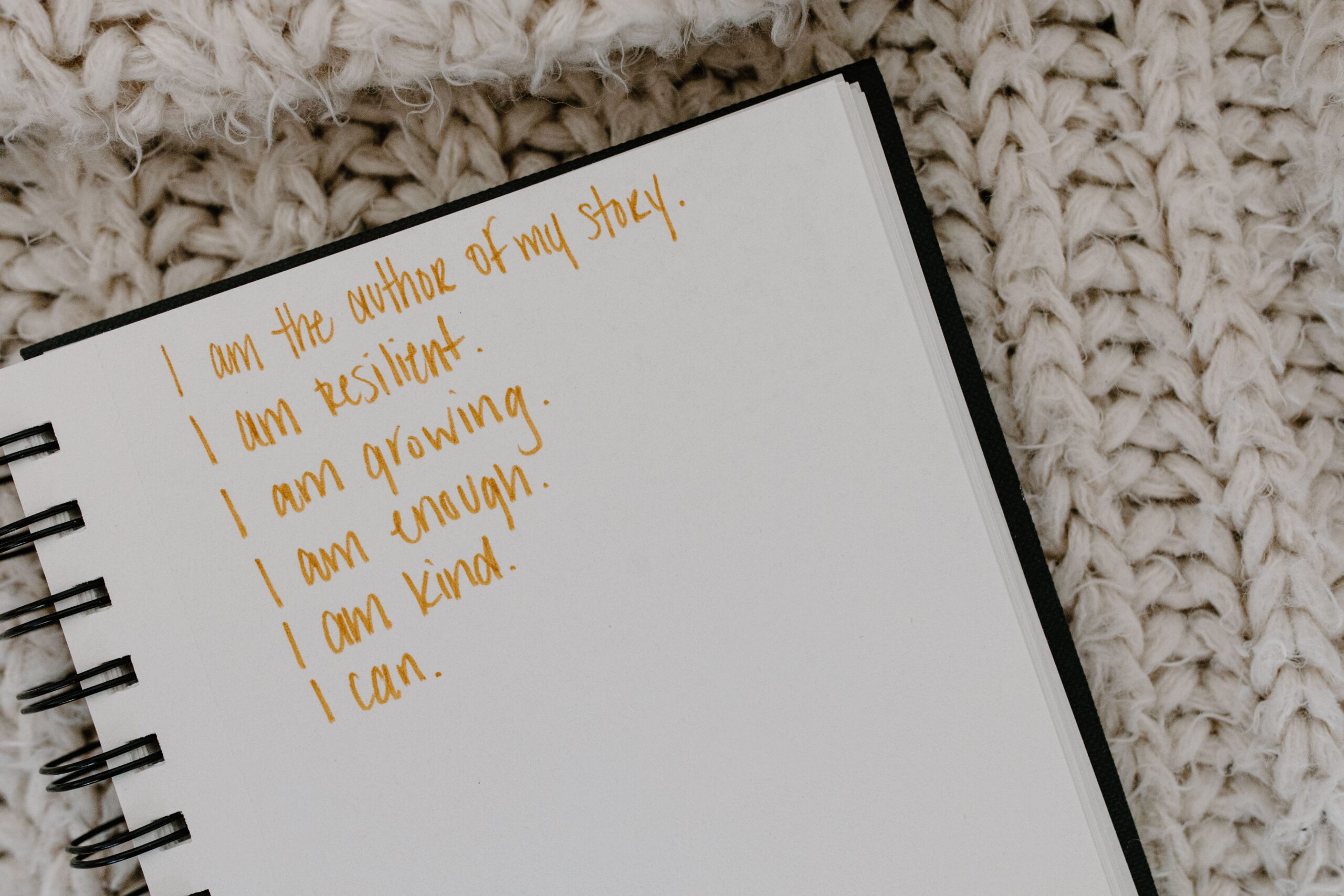 Journal resting on a cream knit blanket representing intentional living and mindful spending